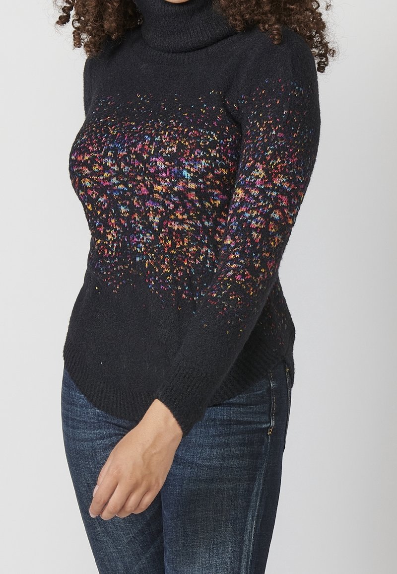 Černý rolák s vícebarevným flekatým vzorem na horní části; žebrované manžety a lem; měkký pletený materiál.