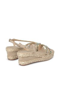 Sandali con zeppa beige, suola in giuta intrecciata, dettagli in strass chiari sulle cinghie e una morbida texture in camoscio. Chiusura con fibbia regolabile.