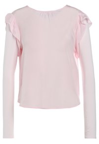 Haut à manches longues en tissu rose clair avec accents volantés aux épaules, encolure ronde et coupe décontractée. Texture lisse et design simple.