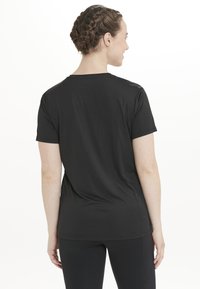 Schwarzes T-Shirt mit kurzen Ärmeln aus weichem, leichtem Stoff. Es hat einen runden Halsausschnitt und eine lockere Passform mit geradem Saum.