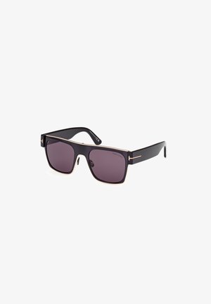 Gafas de sol cuadradas negras con lentes oscuros, detalles metálicos acentuados en dorado a lo largo del marco y gruesas varillas de plástico negro.