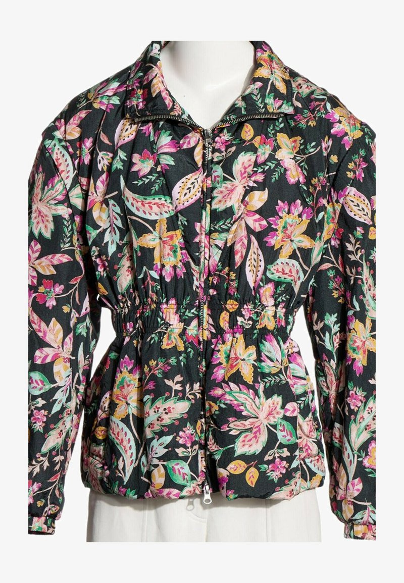 Veste noire zippée avec taille élastique et imprimé floral coloré rose, jaune et vert sur les longues manches et le col.