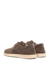 Braune Wildlederschuhe mit einer strukturierten Oberfläche, ausgestattet mit einem flachen Design, beige Gummisohle und Schnürverschluss. Weiche Innenauskleidung.