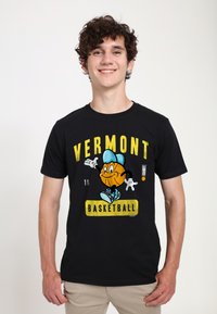 Černé tričko s potiskem kreslené postavy basketbalisty v modré čepici, obklopené žlutým textem: "VERMONT BASKETBALL" a číslem "16."
