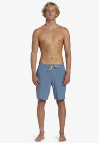 Lichtblauwe zwembroek met een trekkoordsluiting, vo pockets en een klein logo op het linkerbeen. Glad materiaal, knielang ontwerp.