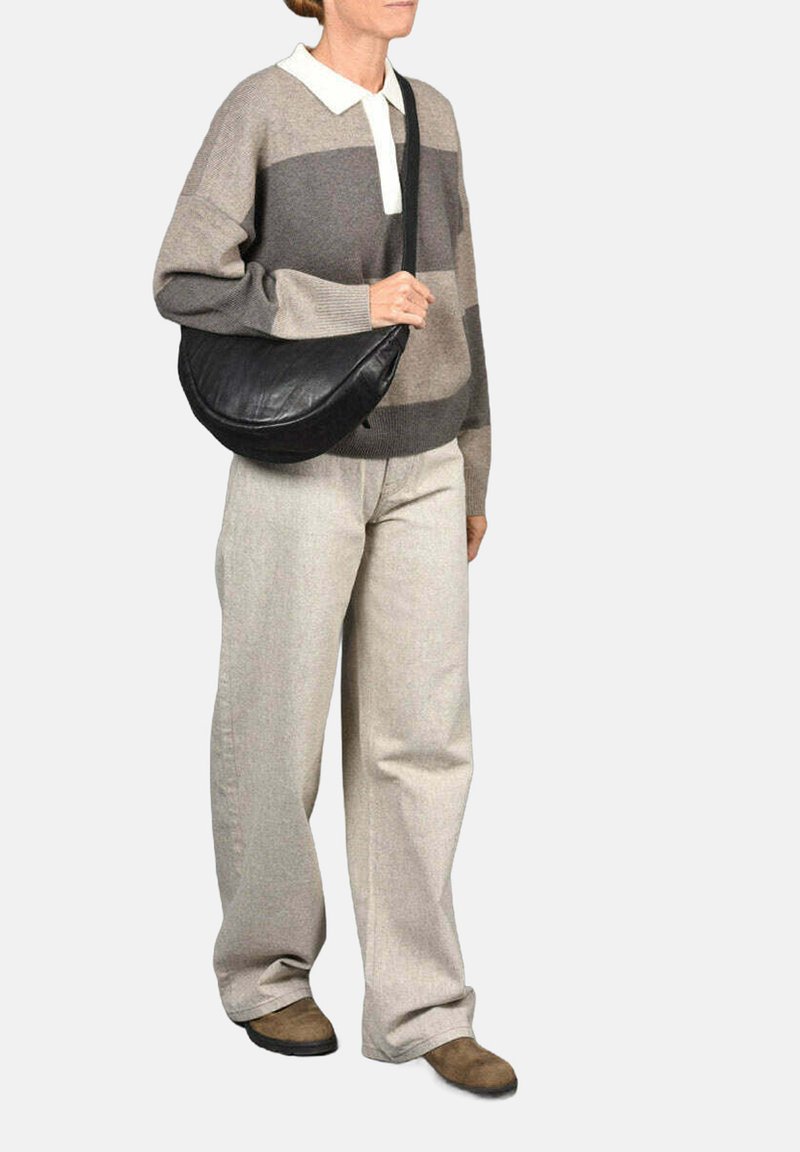 Suéter de punto grueso con rayas grises y beige, cuello blanco; combinado con pantalones anchos beige y un bolso de hombro de cuero negro.