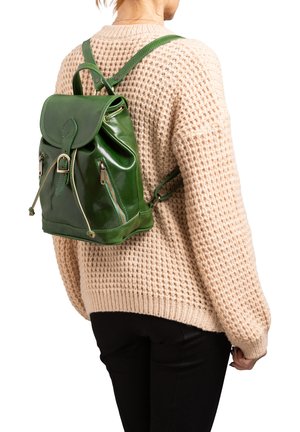 Sac à dos en cuir vert avec une fermeture à cordon, des zips latéraux et un rabat cousu. Présente des bretelles ajustables et une finition brillante.