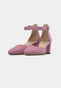 Ρόζ σουέντ γόβες με φαρδιά φτέρνα, στρογγυλεμένη μύτη και λουράκι στον αστράγαλο με αγκράφα. Μαλακή υφή και δομημένος σχεδιασμός.