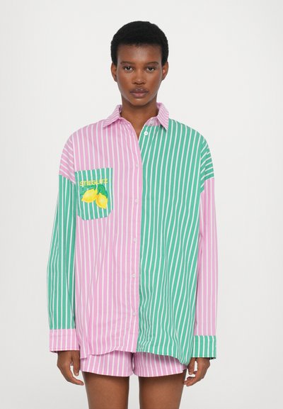 Chemise oversize rayée avec des sections rose et verte, mettant en vedette un graphique de citron sur la poche poitrine et un devant à boutons.