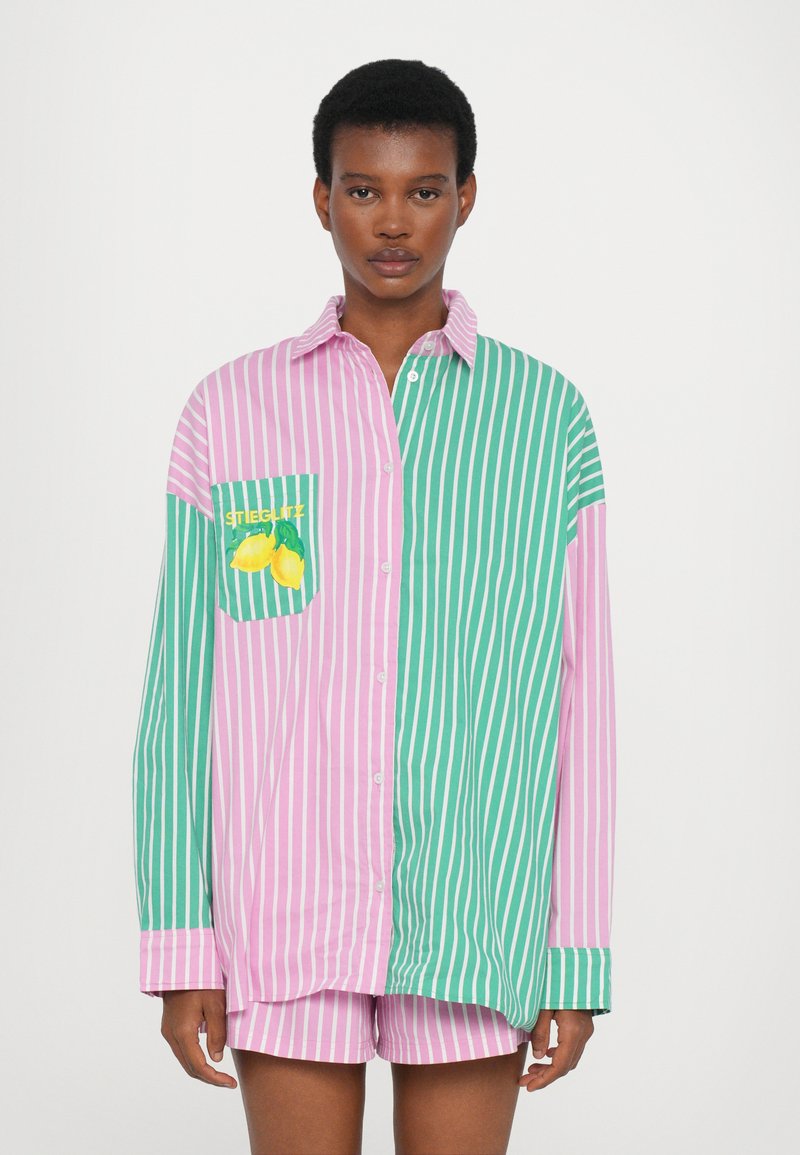 Stribet oversized skjorte med pink og grønne sektioner, udstyret med en citron-grafik på brystlommen og knaplukning foran.