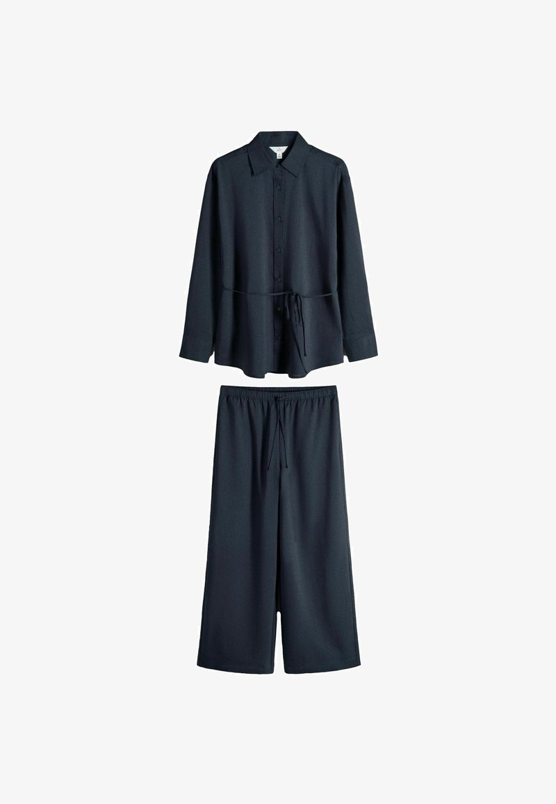 Cămașă bleumarin închis cu mâneci lungi, nasturi și guler, și pantaloni largi asortați cu talie elastică și șnur.