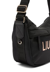 Borsa a spalla nera in nylon con una tracolla texturizzata, hardware in rosé oro e chiusura a zip con un dettaglio del logo sul lato.