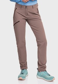 Braune Outdoor-Hosen im Slim Fit mit Reißverschlusstaschen und einem glatten, leichten Stoff. Kombiniert mit türkisfarbenen Wanderschuhen.