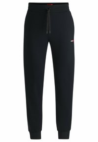 Svarta sweatpants med elastisk midjeband och dragsko, smalnande ben och en liten logotyp på vänster lår. Mjuk tygkänsla.
