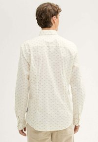 Weißes Langarmhemd mit kleinem, sich wiederholendem Rautenmuster in Hellgrau. Verfügt über einen Button-Down-Kragen und Knopfmanschetten. Glatte Stofftextur.
