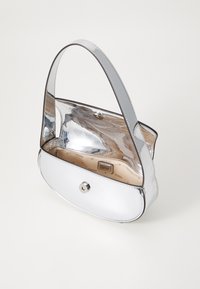 Bolsa de ombro metálica prateada com forma curva, textura suave, fecho com aba na parte superior e uma única alça ajustável. O interior tem forro personalizado.