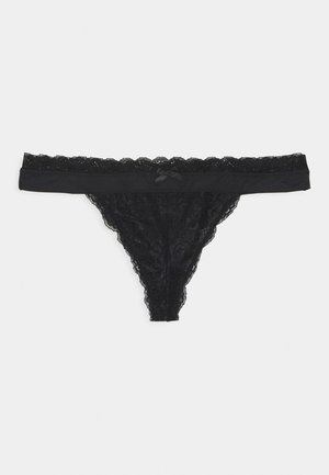 Black lace thong underwear with scalloped edges and a small satin bow on the waistband, displayed flat on a white background.
