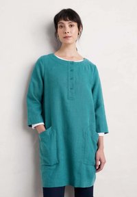 Teal linnen jurk met driekwart mouwen, ronde halslijn, een knoopsluiting aan de voorkant en twee zijzakken. Glad textuur, casual ontwerp.