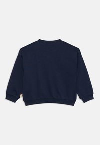 Sudadera azul marino hecha de tela suave. Cuenta con un cuello redondo, mangas largas y puños acanalados. Incluye una pequeña etiqueta en el costado.