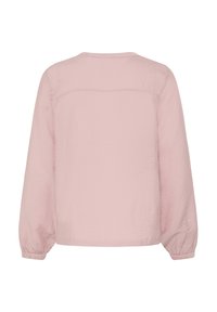 Světle růžové tričko s dlouhým rukávem a jednoduchým kulatým výstřihem s nařasenými manžetami. Vyrobeno z hladké, mírně pomačkané látky s detaily švu na zádech.