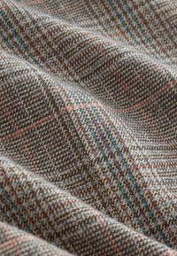 Wool fabric featuring a textured houndstooth pattern in shades of gray, brown, and subtle accents of blue and red threads.