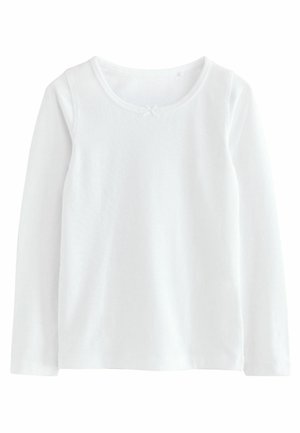 Camicia bianca a maniche lunghe in morbido cotone, con scollatura rotonda e un piccolo dettaglio a fiocchetto decorativo sul davanti.