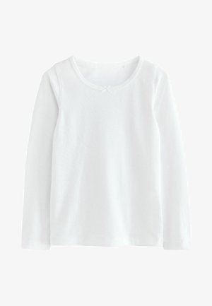 Valkoinen pitkähihaista paitaa pehmeästä puuvillasta, jossa on pyöreä kaula-aukko ja pieni koristeellinen nauhaketju edessä.