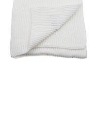 Coperta bianca lavorata a maglia, con una texture a coste, piegata con un angolo sollevato per mostrare i dettagli del motivo.