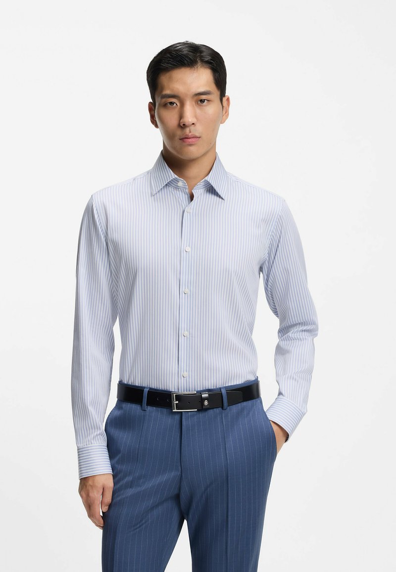 Camicia a righe azzurro chiaro e bianco con colletto button-down, maniche lunghe e vestibilità elegante, abbinata a pantaloni blu scuro a righe sottili e cintura nera.