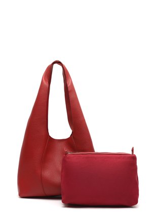 Crvena kožna torba za rame s širokom naramenicom uz manju crvenu pravokutnu torbicu sa zipom na bijeloj pozadini.