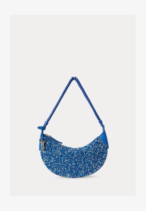 Modrý kabelka v tvare polmesiaca pokrytá malými modrými a bielymi korálkami s uchom a zipsom zdobenými rovnakými korálkami.