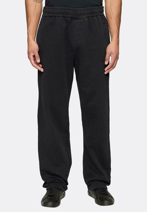 Pantalones de chándal negros hechos de un material suave, con una cinturilla elástica, bolsillos laterales y un ajuste holgado de pierna recta.
