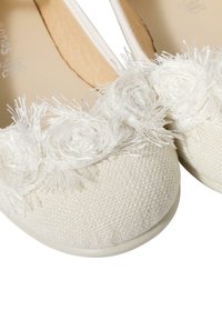 Ballerine bianche in tessuto con una trama texture. La punta presenta un design floreale a strati in faux, realizzato con fili bianchi e dettagli.