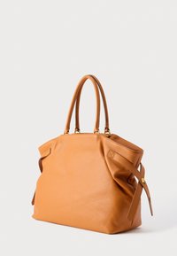 Ādas lielā soma siltā oranžā krāsā ar diviem sapīto rokturiem, mīkstu korpusu un sānu siksnām ar zelta detaļām. Gluda tekstūra.