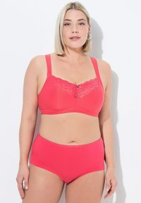 Korálově růžová podprsenka s krajkovým detailem na vrchu a dekorativní mašlí, spárovaná s odpovídajícími vysokými kalhotkami, vyrobenými z hladké látky.