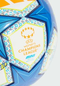 Mali nogometna lopta s plavim, narančastim i bijelim panelima. Ima logo UEFA Lige prvakinja za žene i uzorke zvijezda duž šavova.