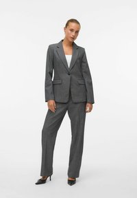 Grå skreddersydd dress med enbladsblazer med to lommer og vide bukser. Jevnt stoff med et subtilt mønster.