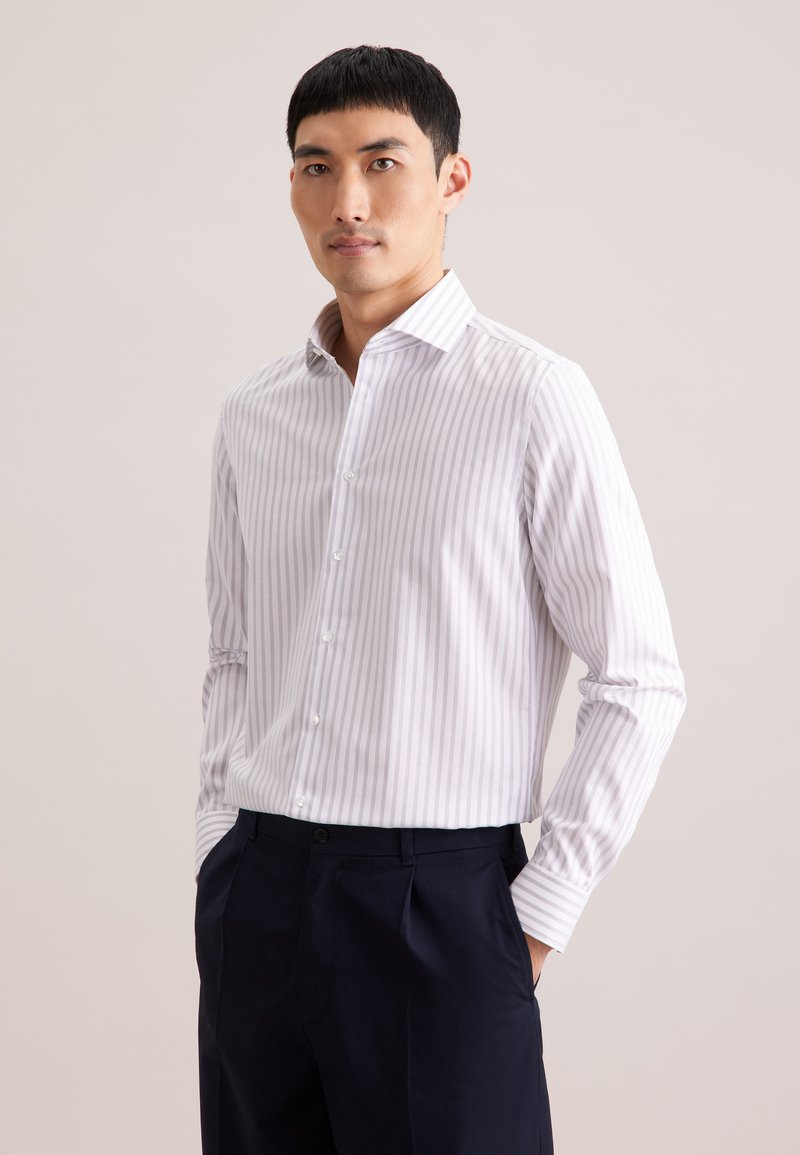 Wit overhemd met lange mouwen met lichtpaarse strepen, klepkragen met knopen en een voorsluiting, gecombineerd met een donkere broek. Gladde textuur.