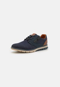 Chaussures en tricot bleu marine avec un talon en cuir marron contrastant, un design à lacets, un dessus texturé et une semelle extérieure beige flexible.