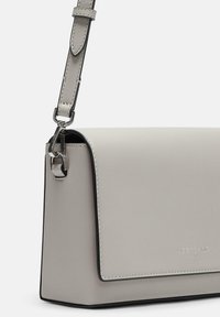 Borsa a mano in pelle grigia con un design strutturato, dotata di chiusura a patta, bordi neri a contrasto e tracolla regolabile con hardware metallico.