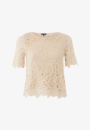 Top in pizzo color crema con maniche corte, caratterizzato da intricati motivi floreali, bordi smerlati e una vestibilità comoda.