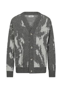 Grå stickad cardigan med V-krage, pryds av ett vitt abstrakt mönster, knappstängning och ribbade ärmslut och nederkant. Mjuk textur.