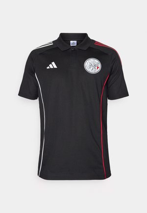 Black polo shirt with white and red side stripes, white Adidas logo, and circular emblem. Made of smooth fabric, featuring a collar and three buttons.