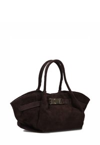 Bruine suède handtas met twee ronde handvatten, een platte basis en een metalen accent in het midden, met een zachte, textuurlijke afwerking.