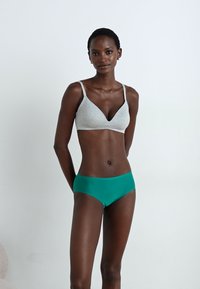 Bralet gri triunghiular cu bretele subțiri, asociat cu chiloți verzi cu talie înaltă. Material neted și elastic, cu un design minimalist.