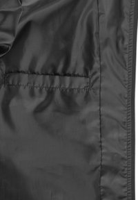 Intérieur de la veste isolante noire, avec un tissu lisse et brillant, comportant une poche cachée et des coutures sans couture pour un fini soigné.