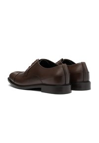 Scarpe eleganti in pelle marrone con una finitura liscia, punta rotonda, lacci e un tacco basso impilato. Presentano dettagli di sartoria delicati.