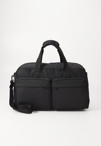 Svart stoff duffelbag med doble frontlommeposer med glidelås, topphåndtak og avtagbar skulderreim. Glatt tekstur og strukturert form.