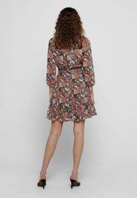 Blumenkleid mit 3/4-Ärmeln, tailliertem Bund, Rüschensaum, mit pinken, grünen und blauen Blumenmustern auf einem dunklen Hintergrund.