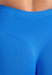 Leggings blu a vita alta realizzati in un tessuto elasticizzato a coste, con una texture liscia e un design senza cuciture in vita.